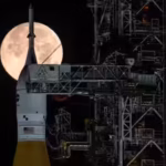 the-full-moon-is-seen-behind-nasas-artemis-ii-sls-space-launch-system-rocket-and-orion-spacecraft-st.avif